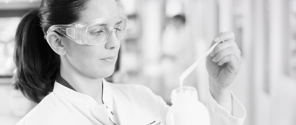 Científica con gafas protectoras analizando una fórmula