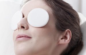 Mujer relajándose con parches fríos en los ojos